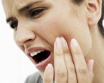 A woman with her hand against her cheek