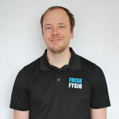 Alt: Portretfoto van Erwin, fysiotherapeut bij Frisk Fysio, lachend en professioneel gekleed, gespecialiseerd in fysio- en revalidatietherapie.