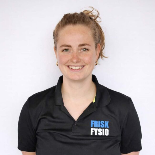 Suze at Frisk Physio Female physiotherapist Suze at Frisk Physio, smiling and professionally dressed in sportswear, ready to help with physiotherapy and recovery.