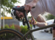 Peter heeft een fietshelm op in Amstelveen en werkt aan zijn zadelpijn door zijn zadel te verstellen.