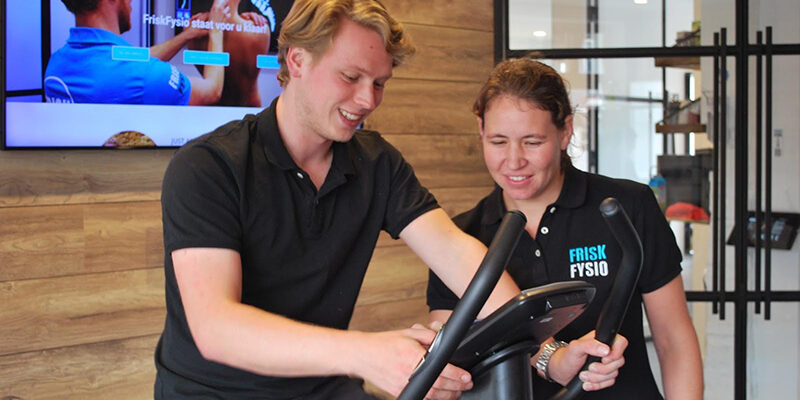 Patiënt op de fiets wordt geholpen aan zijn hoge bloeddruk door een fysiotherapeut van FriskFysio