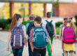 Een groep kinderen lopen naar school zonder rugklachten in Amstelveen