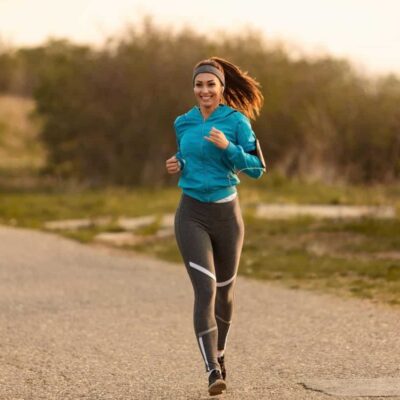 A woman is running along a country lane.