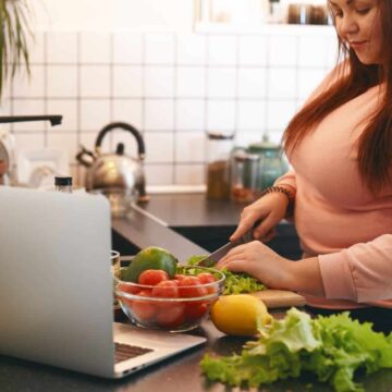 overweight and obesity A woman is chopping vegetables in the kitchen.
