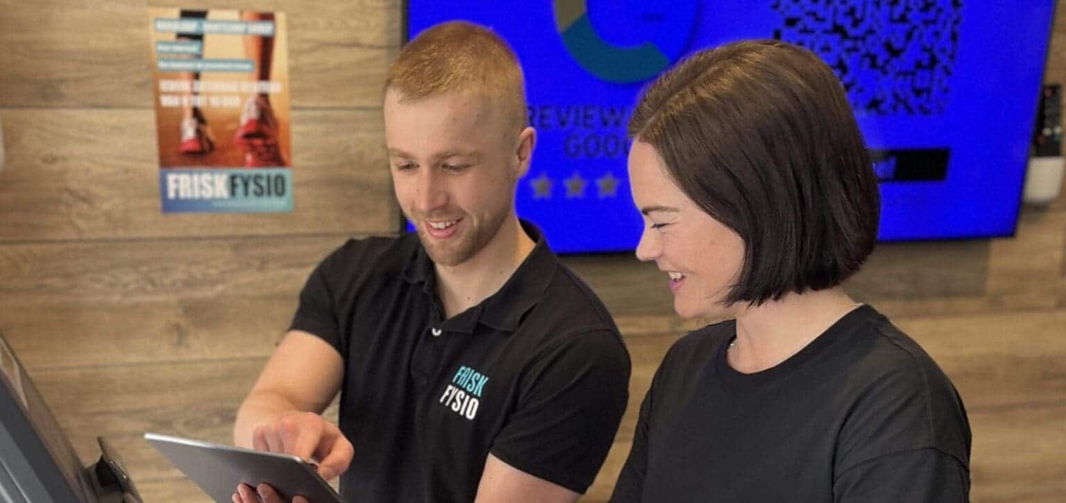Klachten 1 Een medewerker van FRISKFYSIO bespreekt informatie op een tablet met een cliënt.