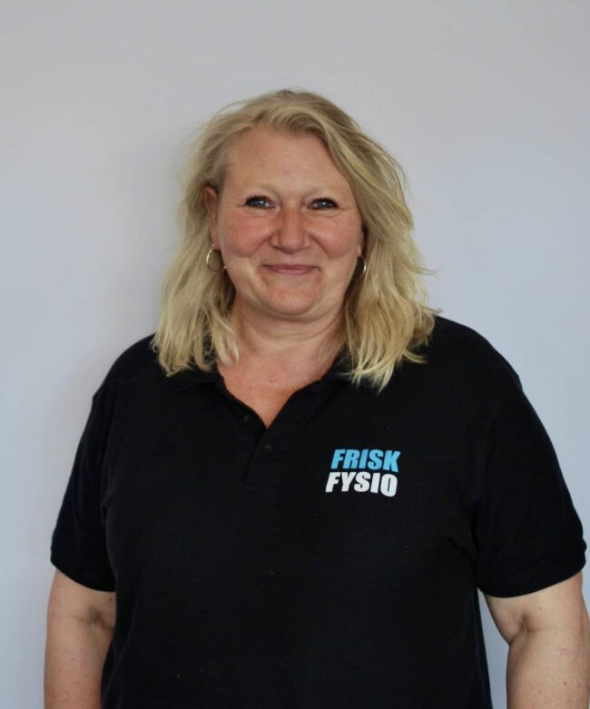 Silver woman with blonde hair smiling and wearing a black polo shirt with the Frisk Physio logo.