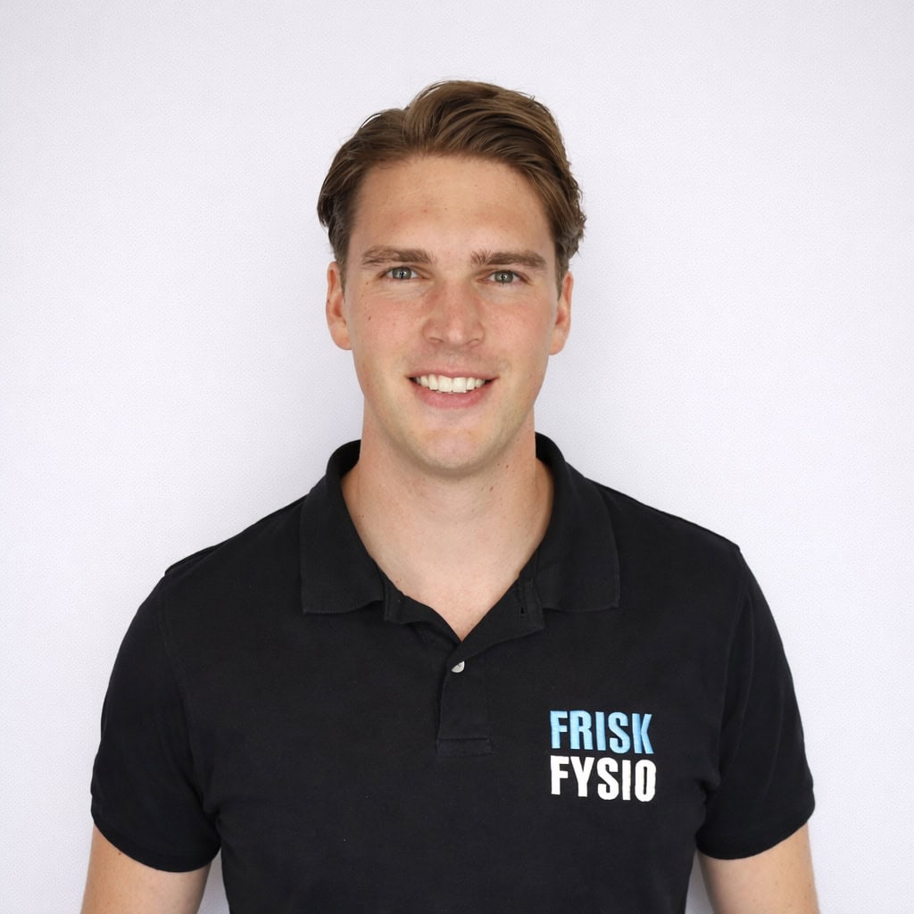Daan K – Frisk Fysio Portret van Daan K, fysiotherapeut bij Frisk Fysio, lachend en professioneel gekleed in een zwart polo met het Frisk Fysio logo.