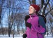 Woman in purple cardigan and red hat exercising outdoors for a positive mindset.