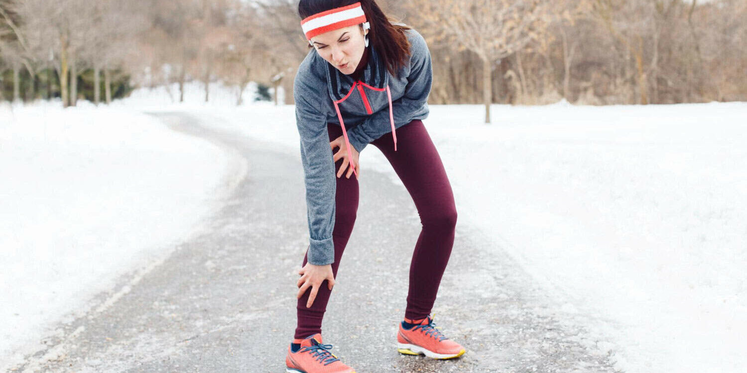 Sportvrouw met knie- en kuitpijn tijdens outdoor training.
