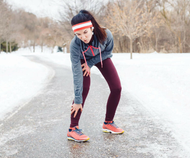 Sportvrouw met knie- en kuitpijn tijdens outdoor training.