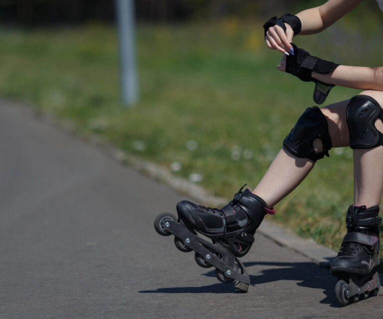 Skateboarder met beschermkleding op straat Meisje zit op een bankje vanwege haar blessures door het skeeleren
