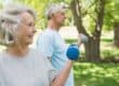 Twee oude mensen bewegen buiten om actief te blijven met parkinson.