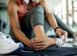 A woman is sitting with her foot raised because she is suffering from Achilles tendon problems after exercising.