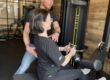 Fysiotherapeut helpt een vrouw in de sportschool om beginnende blessure te voorkomen.