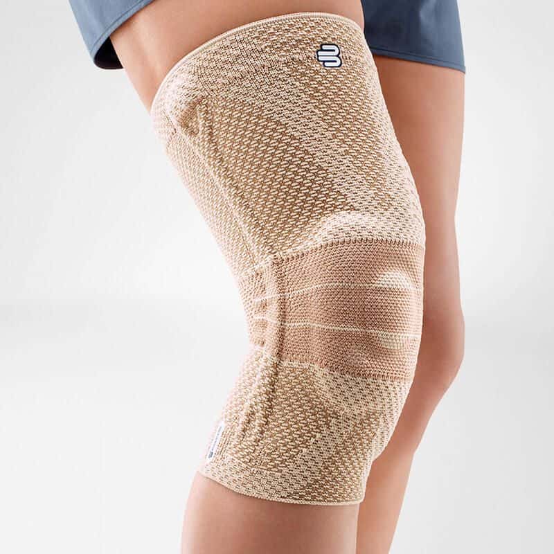GenuTrain A3 kniebrace 4 FriskFysio kniebrace in beige elastische bandage uitbreiding rondom kniegewricht, gericht op ondersteuning en compressie.