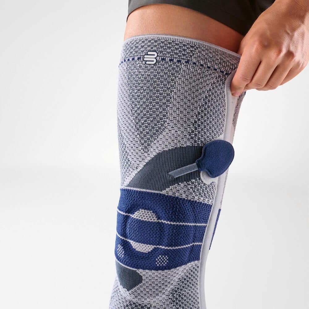 GenuTrain P3 kniebrace 5 GenuTrain P3 kniebrace kniebandage uitgevoerd met grijze en blauwe mesh-materialen voor ondersteuning en stabiliteit.