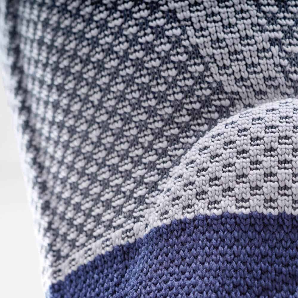 GenuTrain P3 kniebrace 7 Kniebrace in gebreide textuur, close-up van het materiaal met blauwe tinten.