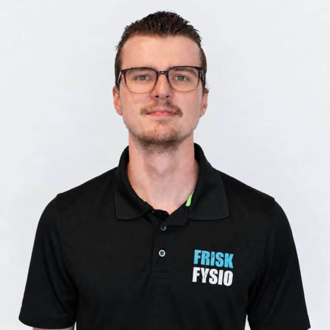 Frisk Fysio staff member in a black polo shirt with a logo, smiling and friendly, professional appearance, healthy lifestyle, physiotherapy practice.