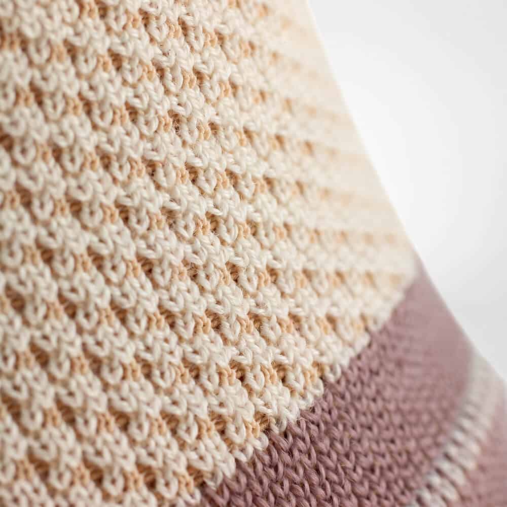 Outdoor Ankle Support 5 Sfeerbeeld van een gebreide, lichte tricot vlak met een combinatie van crème en zacht poederroze tinten.