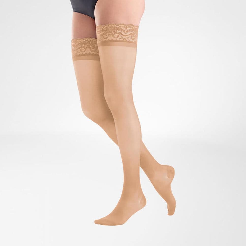 VenoTrain® act SHEER ELEGANCE AG 3 Damesbenen in 力elves katoenen kousen met kanten boord, kniehoogte, huidkleurige maillot op witte achtergrond.