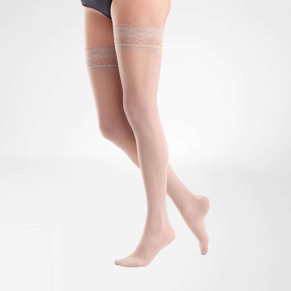 VenoTrain® act SHEER ELEGANCE AG 4 Vrouwelijke benen in kousen, standing pose met lichte huid en lace-kousen bovenaan die suggestie geeft van medische of fysiotherapeutische ondersteuning.
