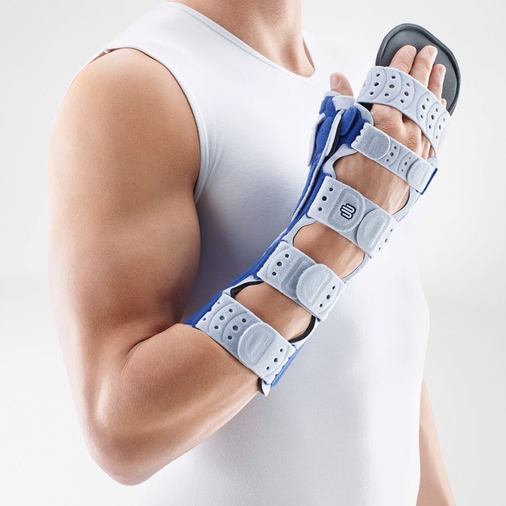 ManuLoc® Rhizo long Plus 1 Strategic arm-mounted synthetic brace for forearm and wrist protection; a man is wearing a white sleeveless T-shirt and a sports brace with a tight-fitting bandage.