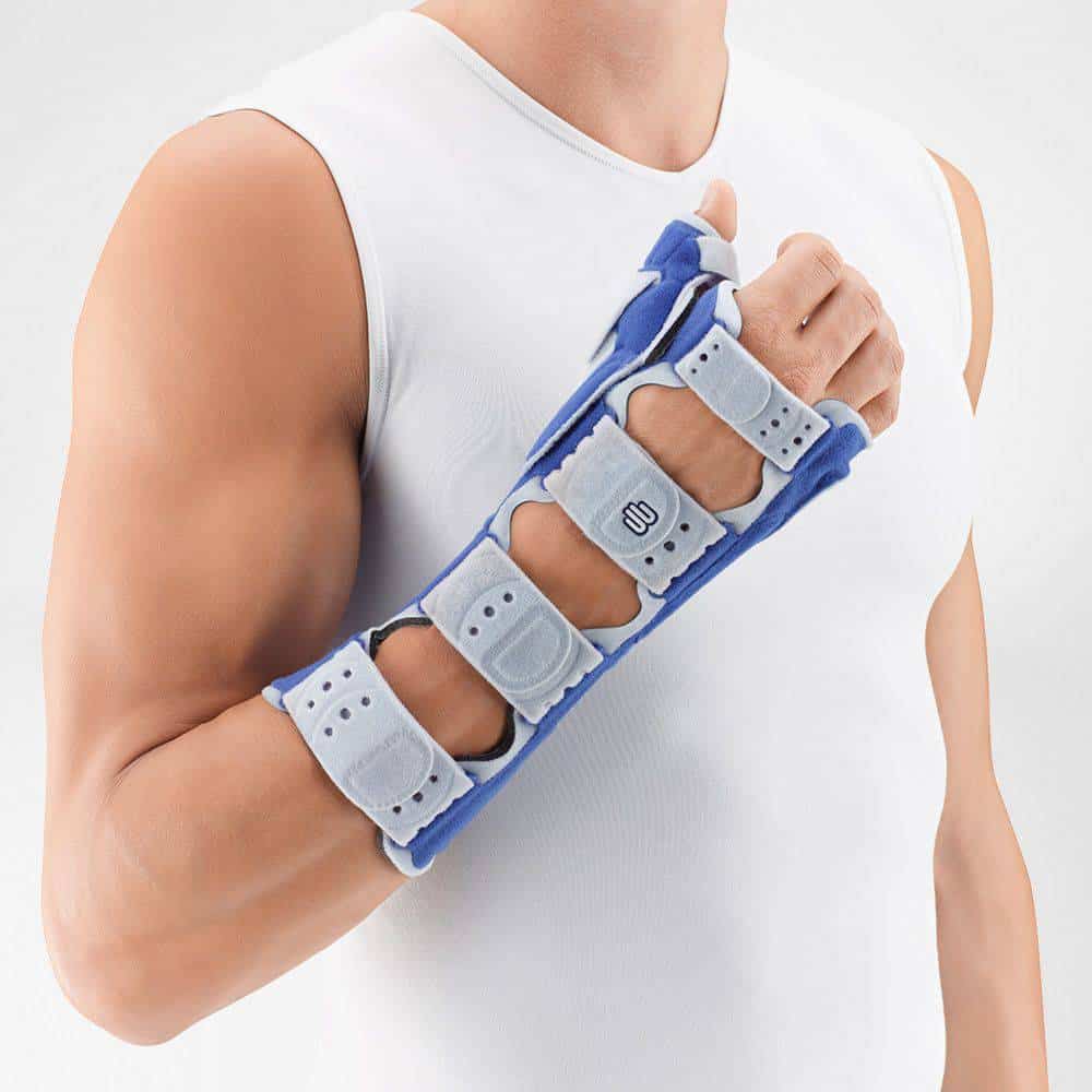 ManuLoc Rhizo long pols- en duimorthese 1 Orthopedische pols/armbrace met vier verstelbare banden en klittenbandsluit, gedragen door man in wit hemd.