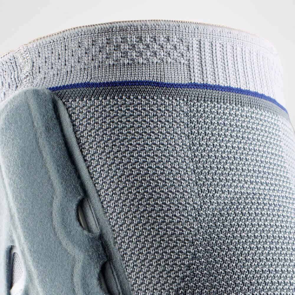 SofTec® Genu 3 Frisostap brace die rug en onderbeen ondersteunt, close-up textuur en ondersteuningseenheid in grijstinten.