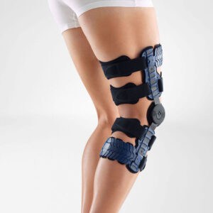 Hoge knie-brace op iemands been, orthopedische kniebrace met bandjes en veters voor ondersteuning na blessure.