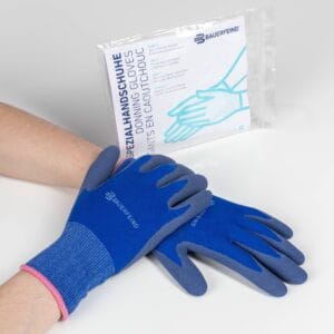 Hands wearing blauwe workhandschoenen van BAUERFEIND, gebruikte handschoenen voor hygiëne en bescherming, naast een uitlegfolder op een witte achtergrond.