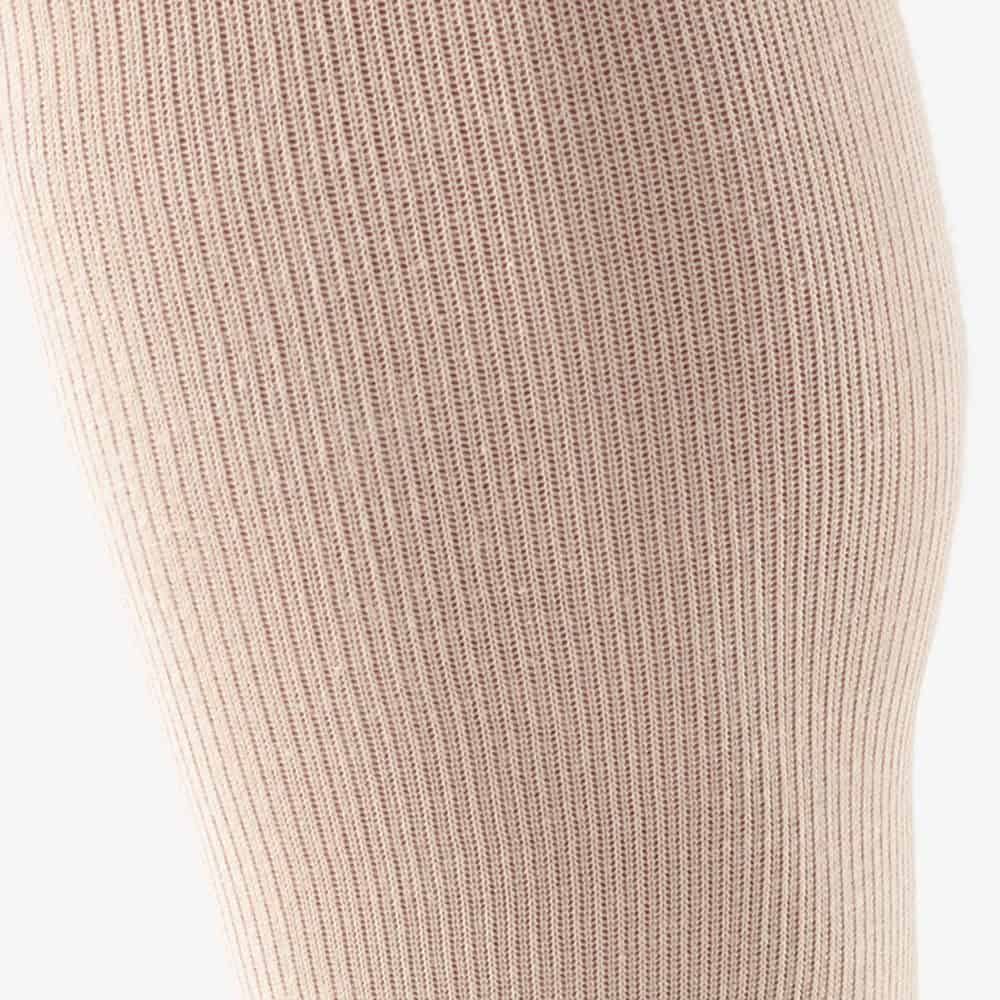 VenoTrain® act COTTON 3 Dicht gebreide huidkleurige kous of beenwarmers op een lichte achtergrond, focus op textuur van breisel.
