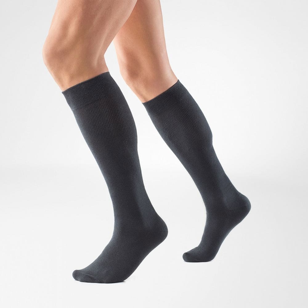 VenoTrain® act COTTON 4 Lange zwarte kousen gedragen door een persoon, duidelijk zichtbare kuiten en beweging, neutrale achtergrond.