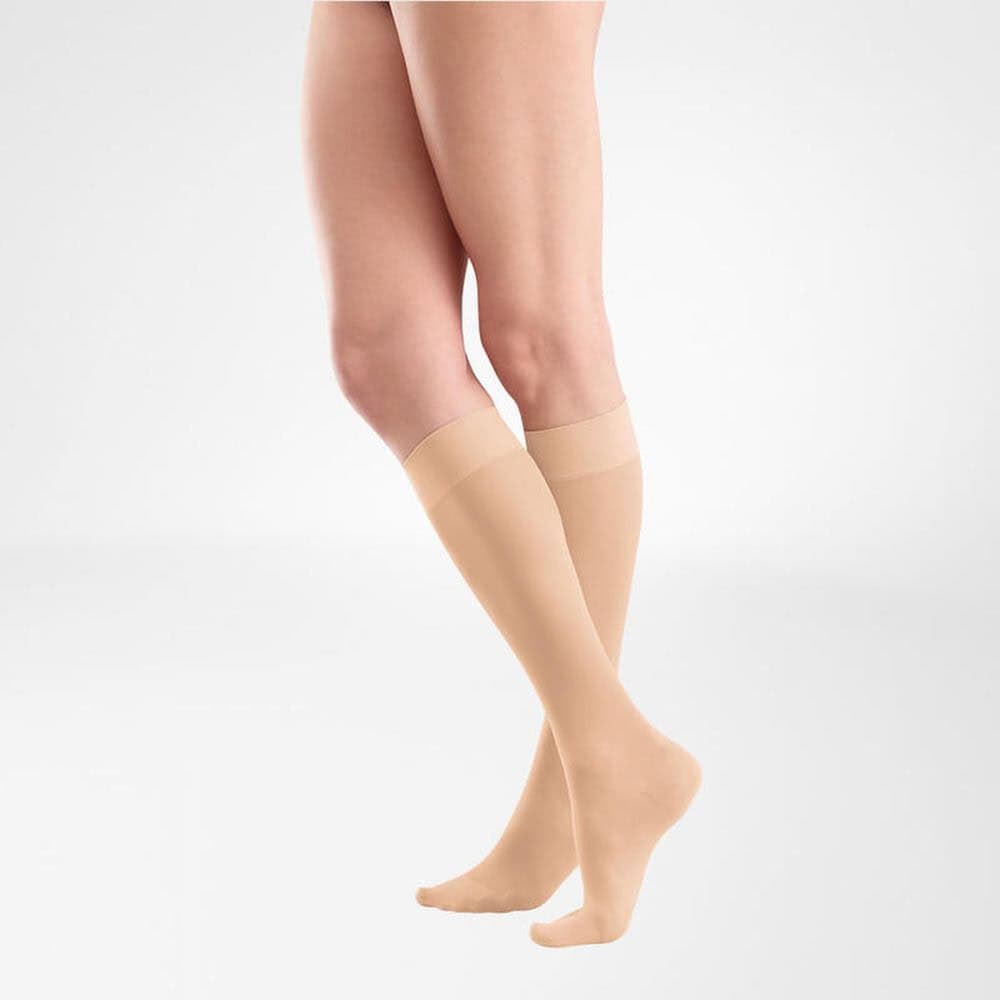 VenoTrain® act SHEER ELEGANCE AD 3 Vrouwelijke benen in beige compressie- of pantykousen, gericht op been- of voetondersteuning.