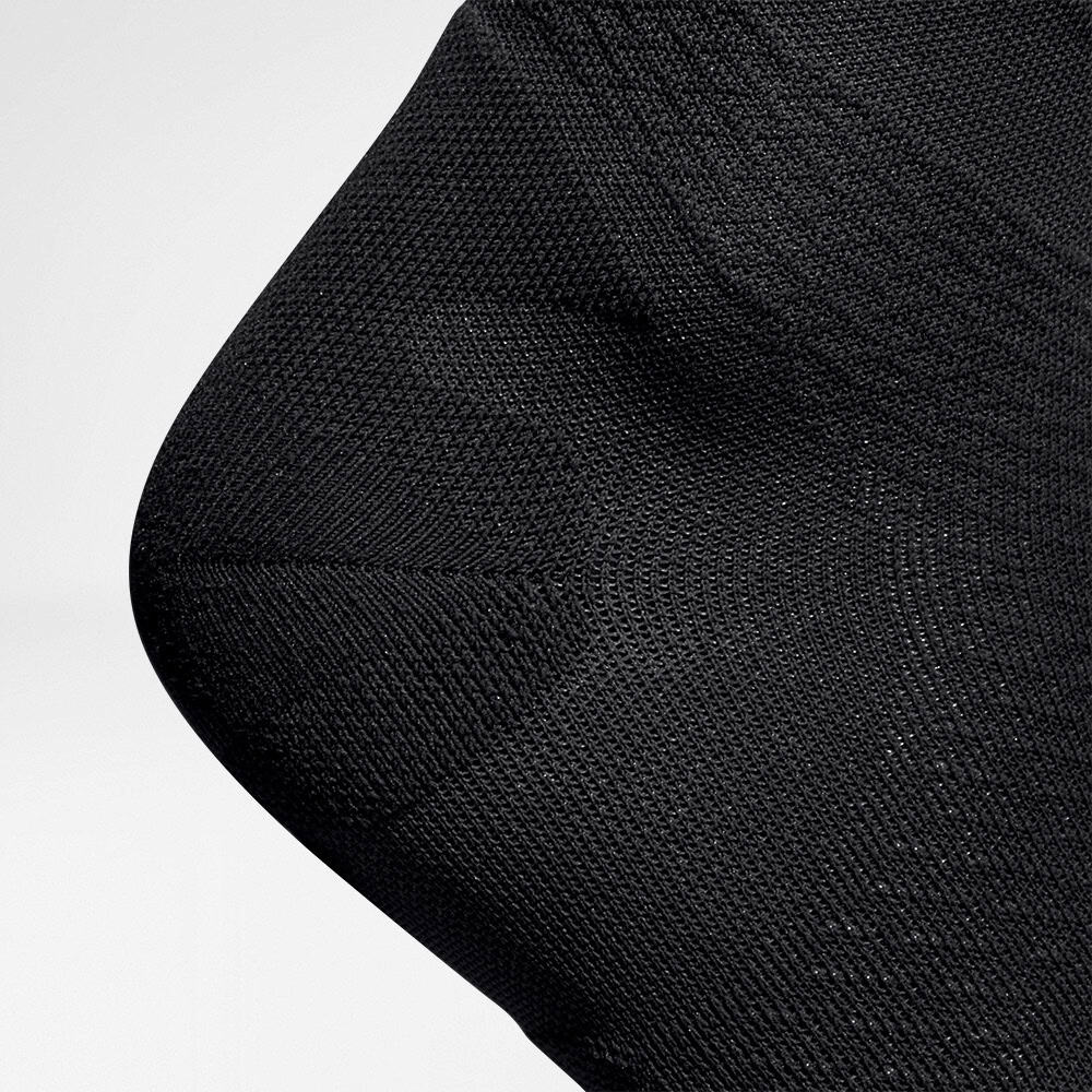 Run Ultralight Compression Socks 6 A close-up of the dense, black knitted fabric on a garment by FriskFysio, showing the texture of the fabric and the seams.