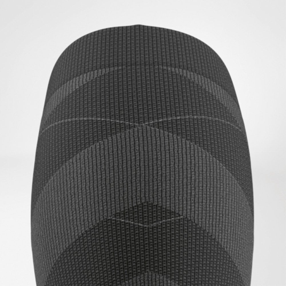 Ski Performance Compression Socks 8 Dicht bij elkaar gevouwen, donkere fotografische close-up van een gebreide, cilindrische stoftextuur alsof het een textielproduct betreft.
