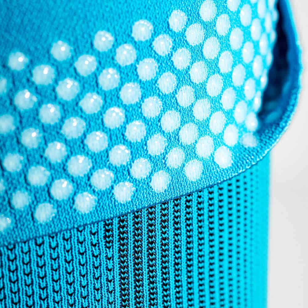 Sports Compression Elbow Support 7 Blauw sportkussen met textuur en prikbordachtige perforaties, close-up afbeelding van fysiotherapie- of sportmaterialen.