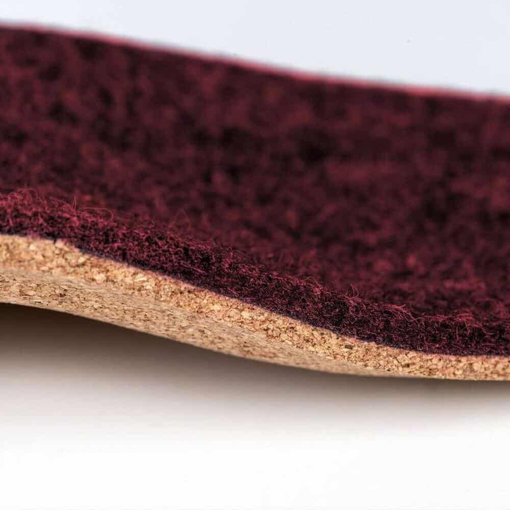 ErgoPad® weightflex 7 Diep rode viltlaag op een houten oppervlak, macro close-up van sportschoenen of -tape materiaal voor fysiotherapie en oefentherapie.