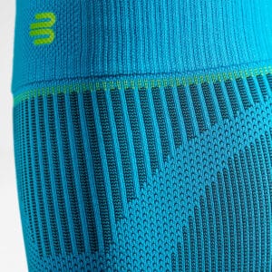 Fris sportkleding met blauw en turquoise patroon, close-up van textuur en gebreide stof, vertoning van elastische tailleband met merklogo.