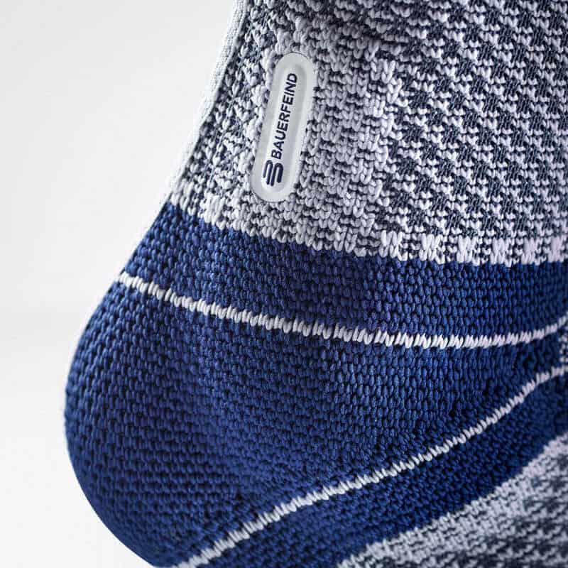 MalleoTrain enkelbrace 6 Mouwen en knie van een blauw/grijs gebreide Brace met label 'BAUERFEND' zichtbaar, geschikt voor ondersteuning bij MalleoTrain enkelbrace.