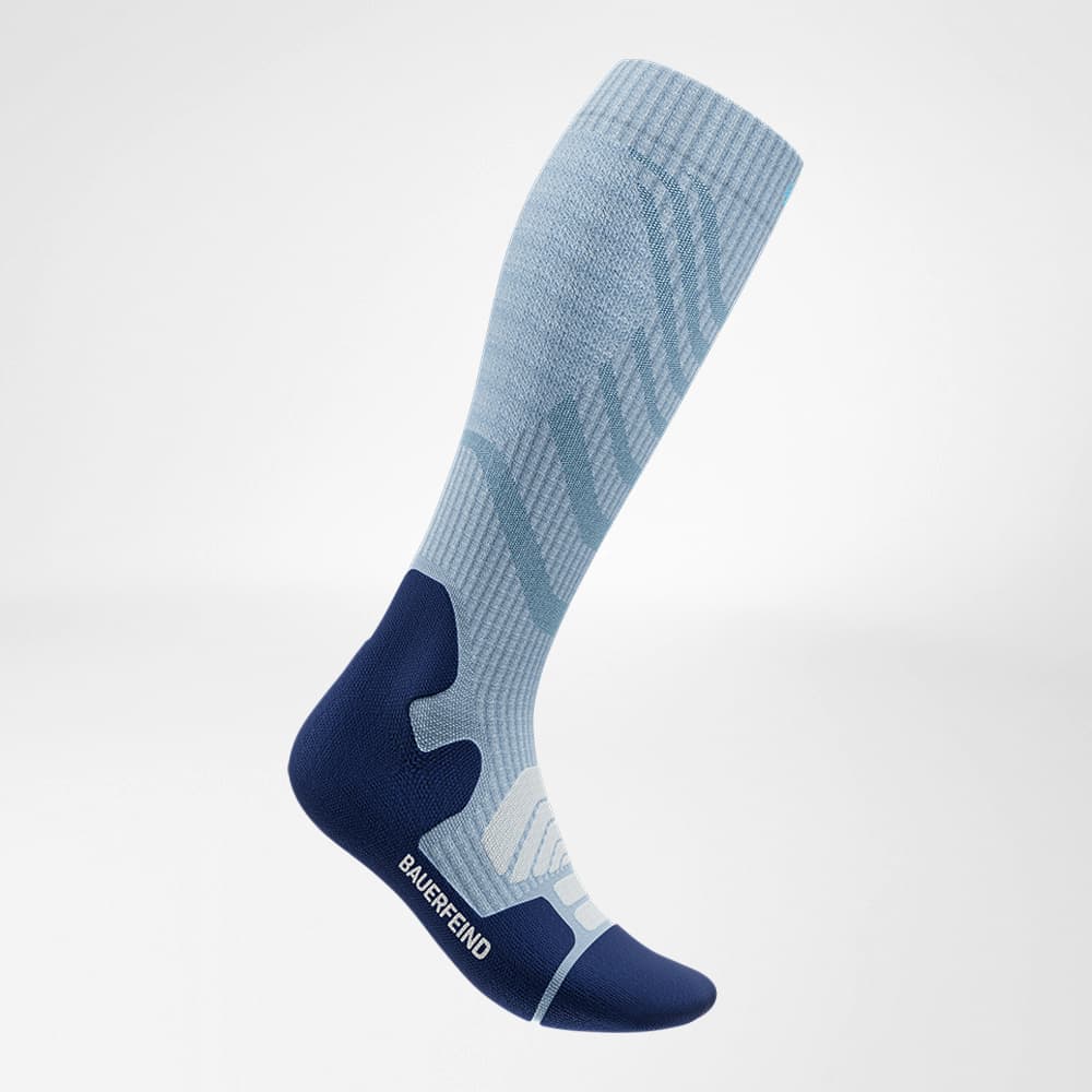 Outdoor Merino Compression Socks 1 Compression knee-high sock in light blue with a dark blue heel and sole, ideal for sport and everyday support.
