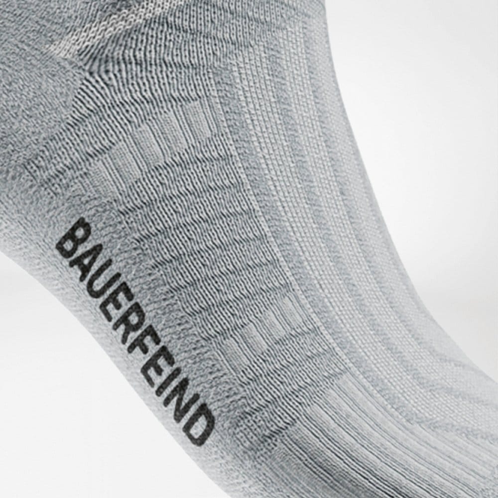 Run Performance Compression Socks 8 Boomvoorkant van een sportkous met het merk BAUERFEIND zichtbaar, grijstinten, close-up.