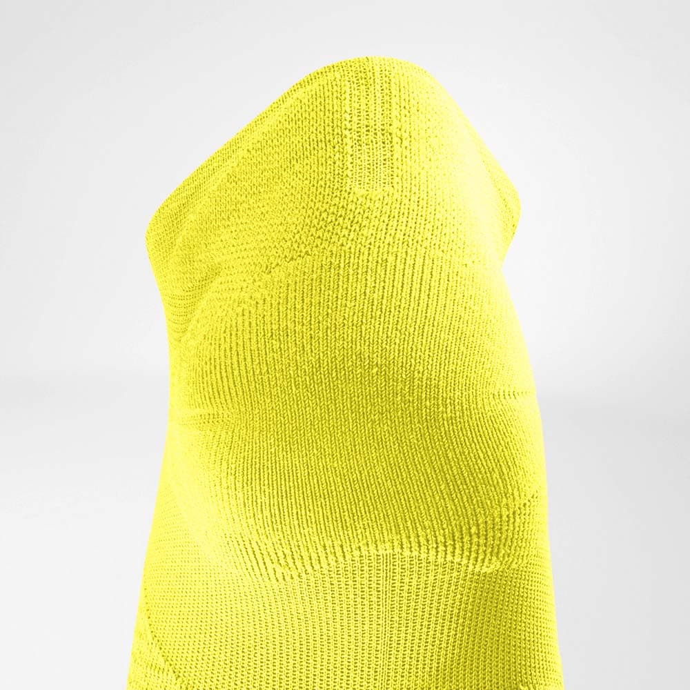 Run Ultralight Low-Cut Socks 5 A clear close-up of a bright yellow knitted hat against a white background, suitable for sportswear and outdoor activities.