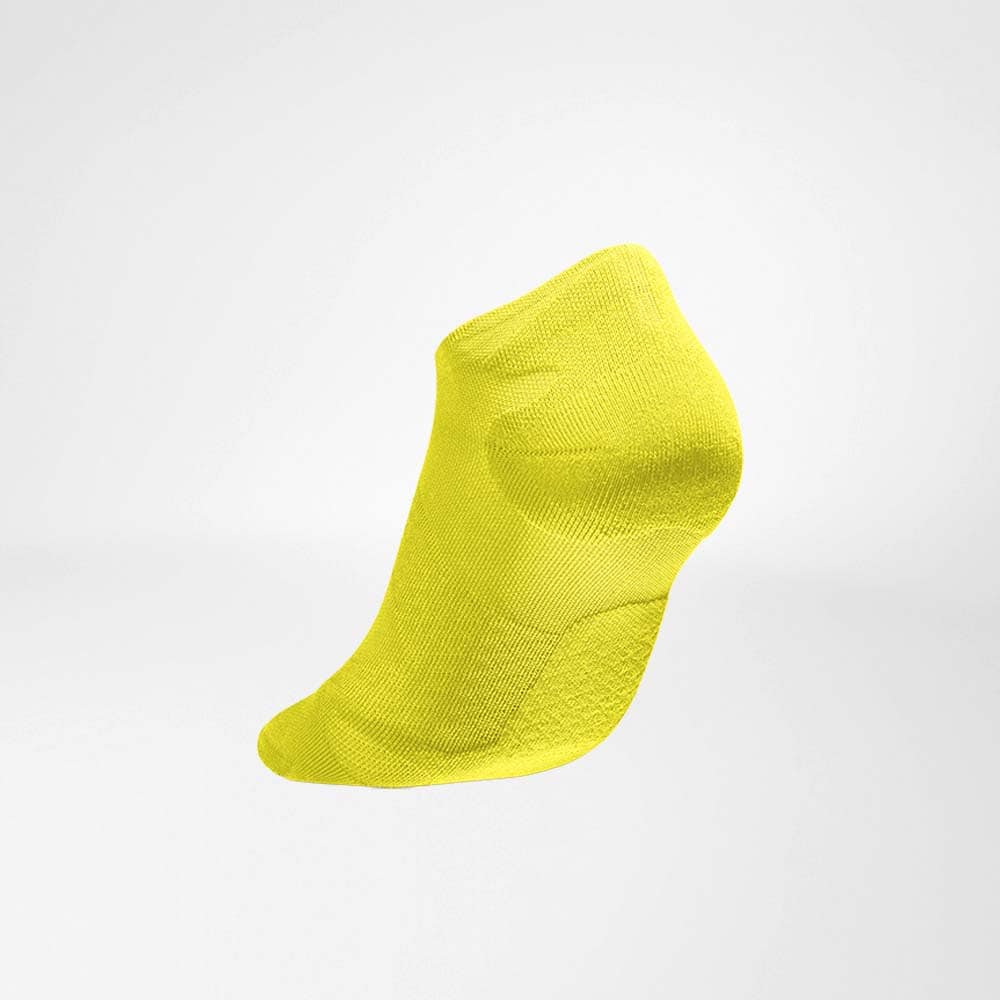 Run Ultralight Low-Cut Socks 3 A bright yellow sock with a short cuff, floating against a white background for FriskFysio.nl SEO-optimised imagery.