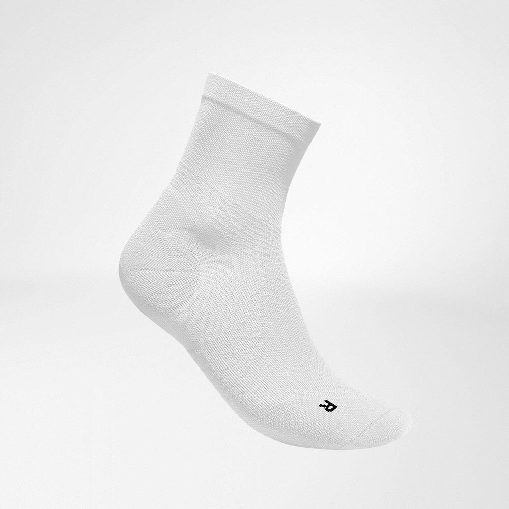 Run Ultralight Mid-Cut Socks 1 White sports socks against a minimalist, plain background, designed to provide support and comfort during training sessions.