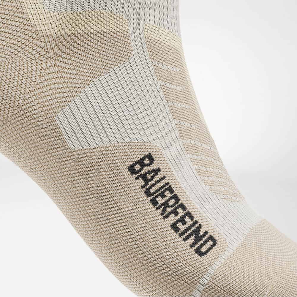Ski Alpine Compression Socks 7 BALRDN-brand compressiekousen in beige en wit met text Balmbrand langs de zools tegen een witte achtergrond.