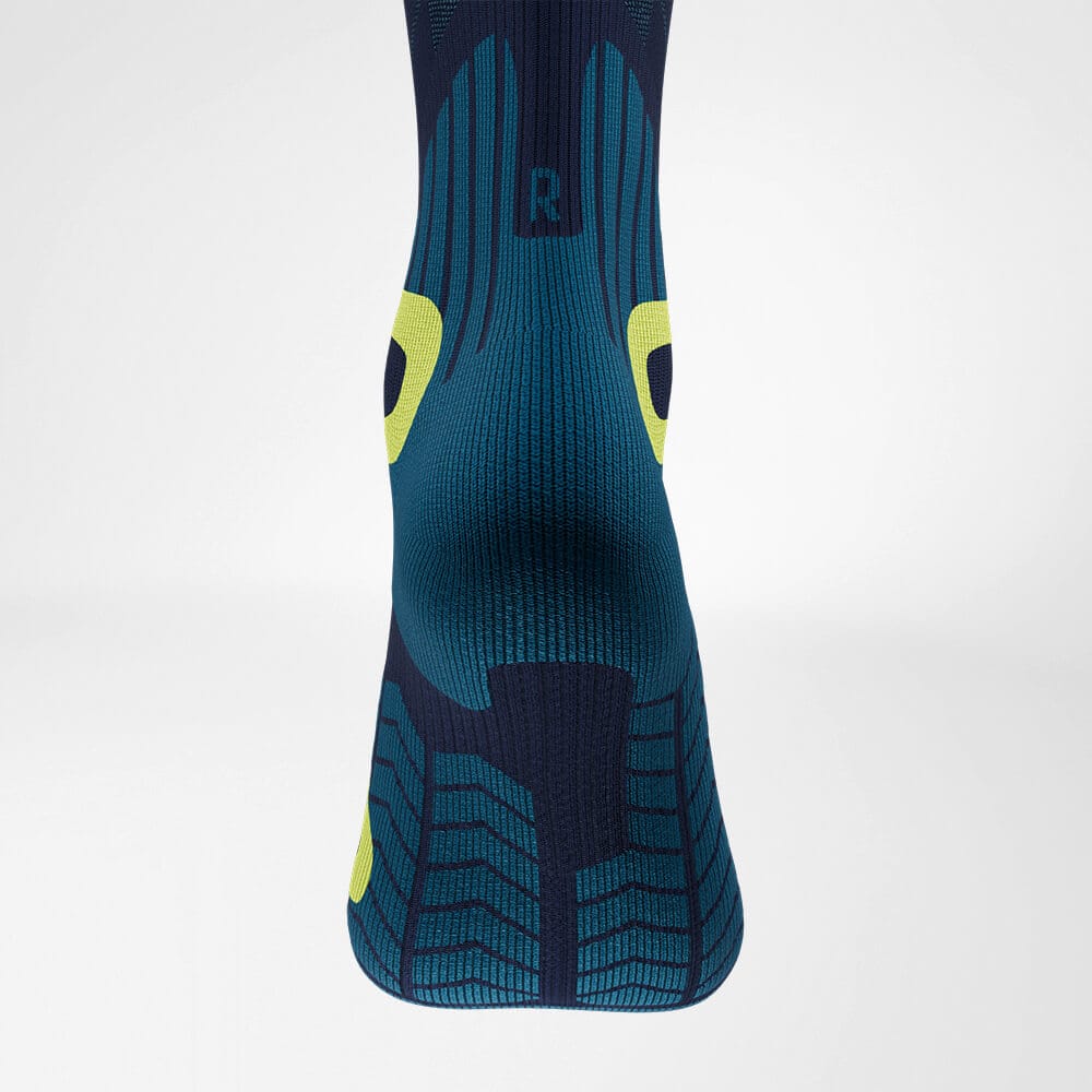 Ski Touring Compression Socks 7 Running socks with an anatomical design and grip pattern in shades of dark blue and teal, with yellow accents on the sides.