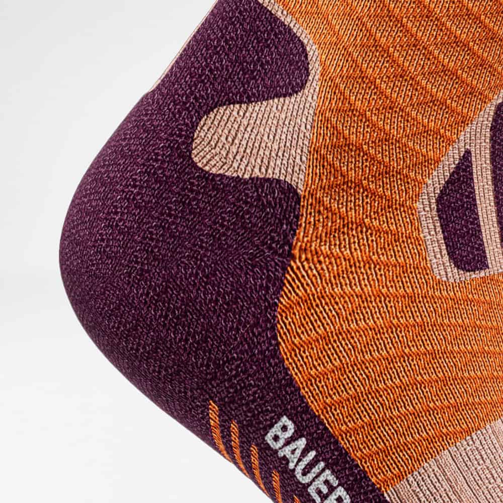 Trail Run Compression Socks 4 Frisse, gedetailleerde oranje en paarse geweven kussenhoes van Frisk Fysio met opvallende patronen.