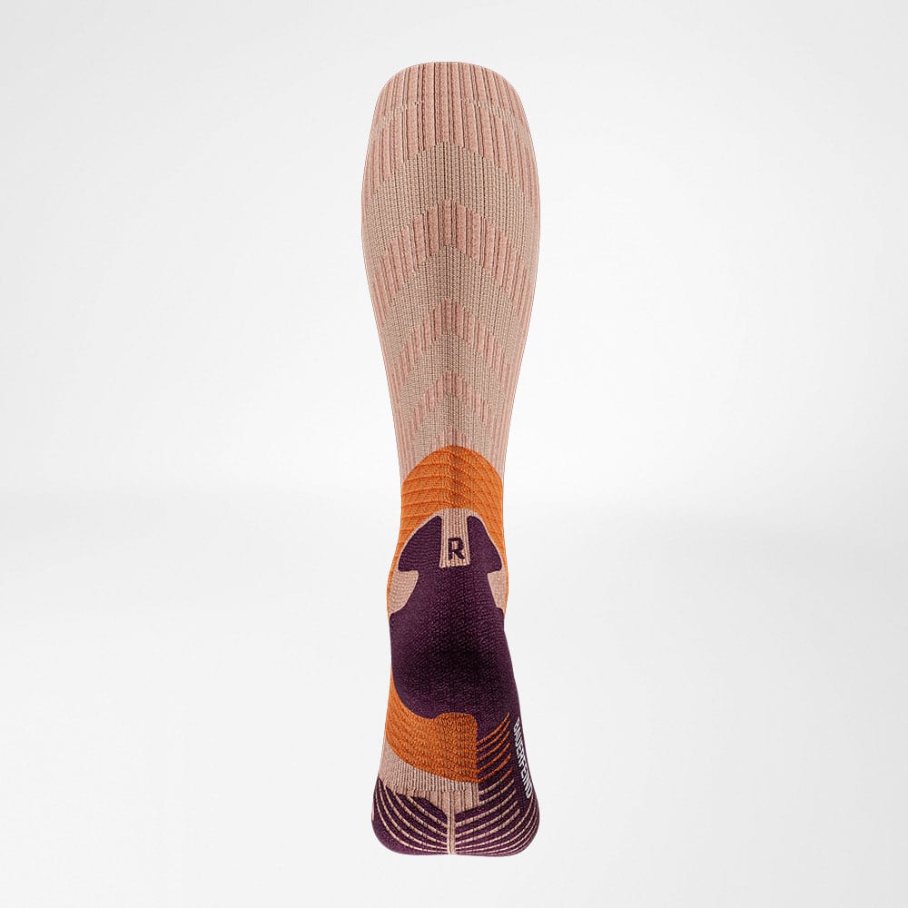 Trail Run Compression Socks 3 Close-up van een sportkous met roze, oranje en paarse tinten en zigzagpatroon, gericht op ondersteuning en comfort.