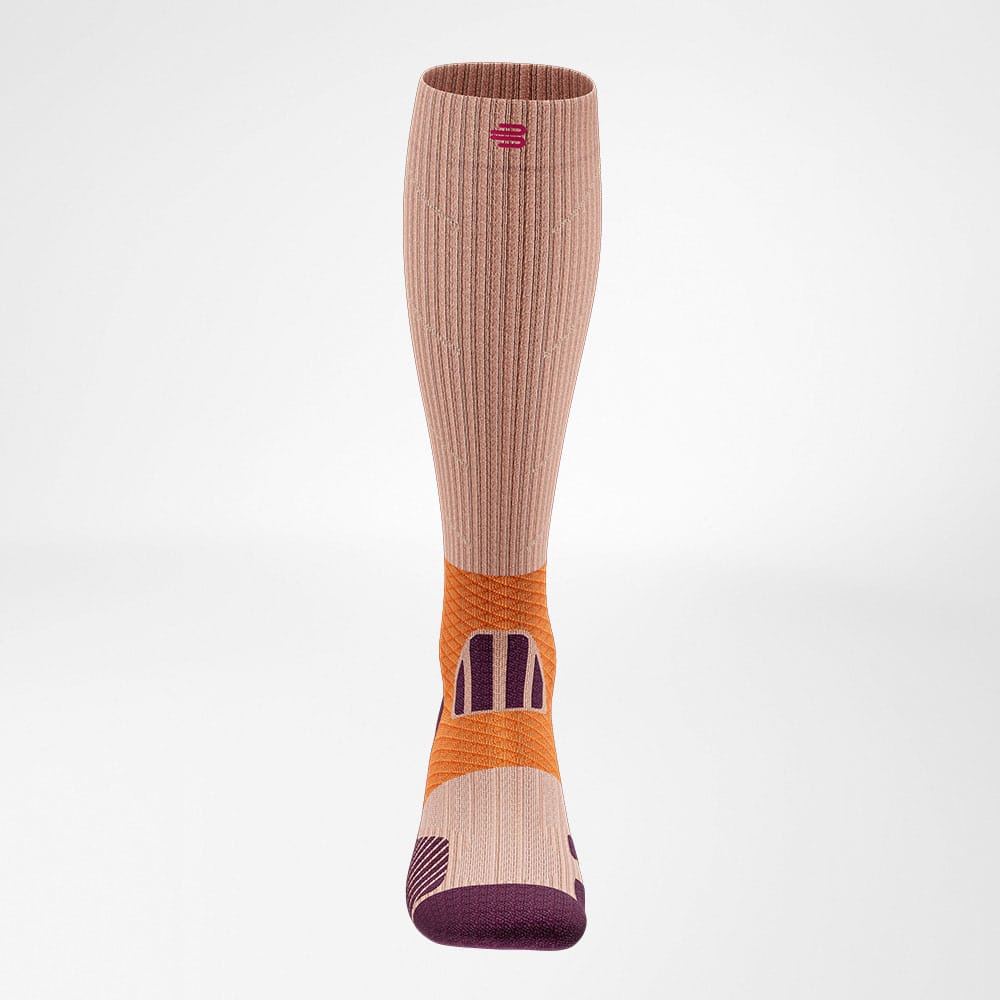 Trail Run Compression Socks 2 Neutrale knie- en kuitcompressie sok in zacht roze en oranje tinten, ontworpen voor ondersteuning tijdens sport en revalidatie.