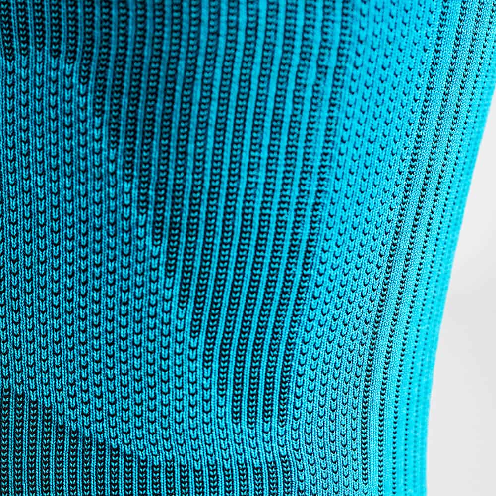 Sports Compression Sleeves Upper Leg 6 Turquoise gebreide stof met rommelende textuur en verticale patronen, close-up voor sportkleding en fysiotherapie-onderwerpen.